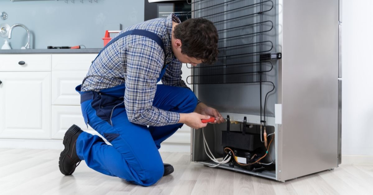 Técnico consertando geladeira